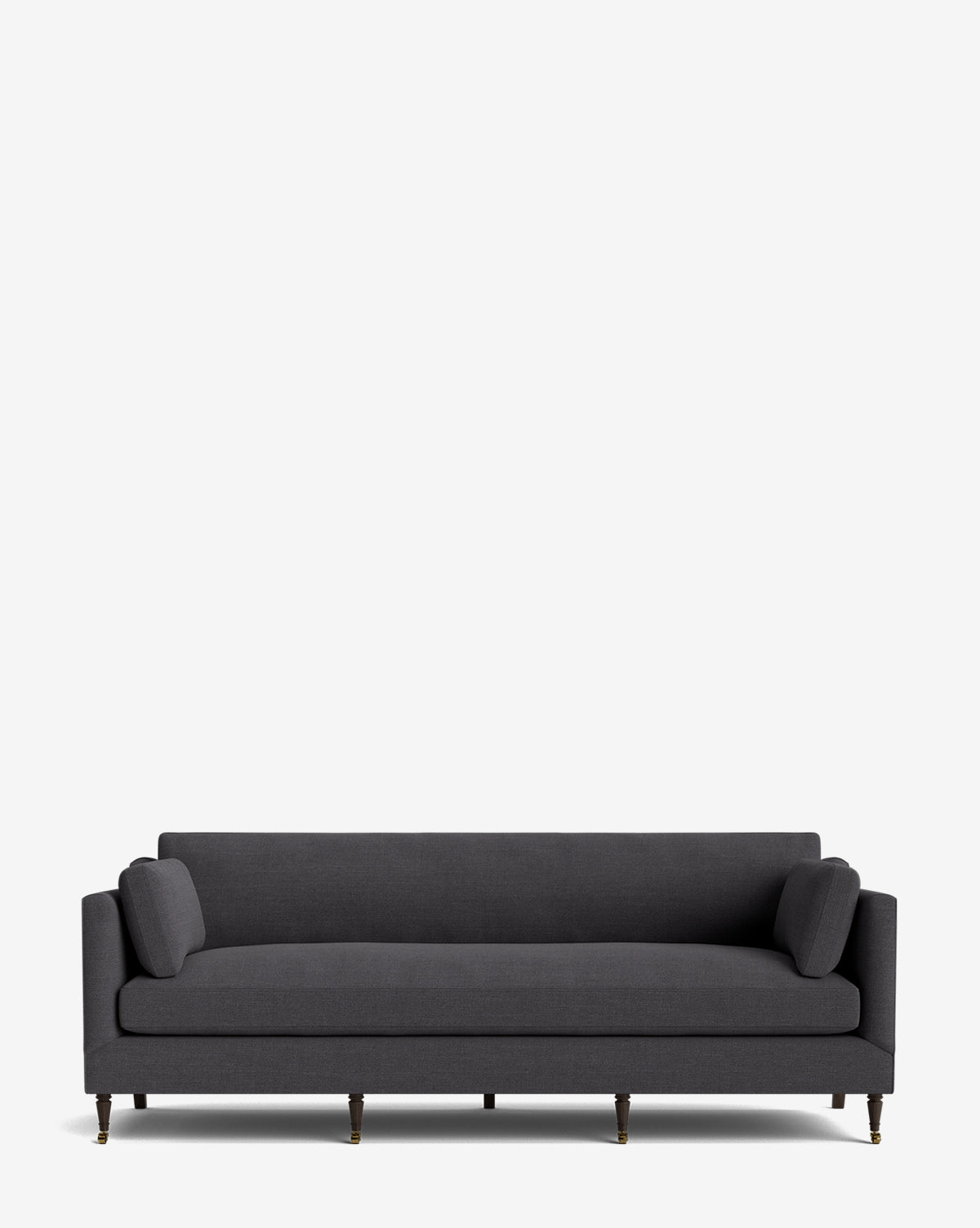The Haverford Upholstered Sofa 90 features a modern dark gray design with two cylindrical bolster pillows and slim wooden legs, set against a plain white background. This customizable sofa brings timeless elegance to any living space, by McGee & Co.