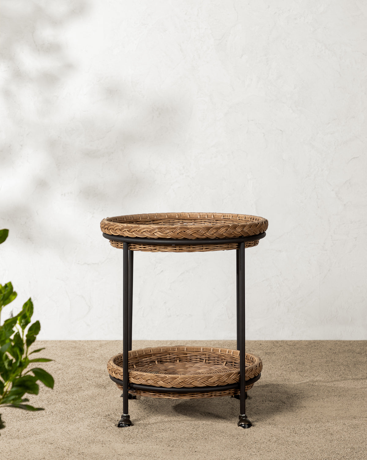 Set on a pebble floor by a textured white wall, sunlight casts soft shadows—ideal for stylish outdoor entertaining, by McGee & Co.