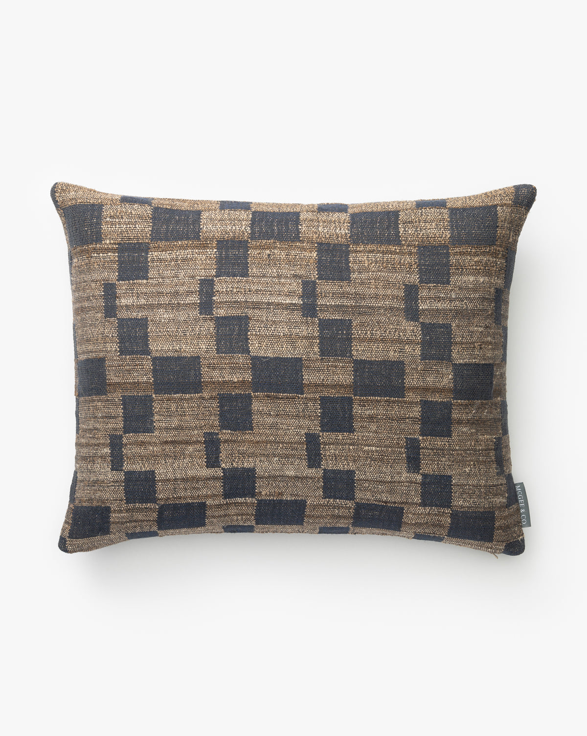 The Hedgerow Navy Pillow Cover is a rectangular decorative cover with a geometric pattern on textured fabric, by McGee & Co. Hand-woven, it has a small fabric tag on the side and is shown against a plain white background.