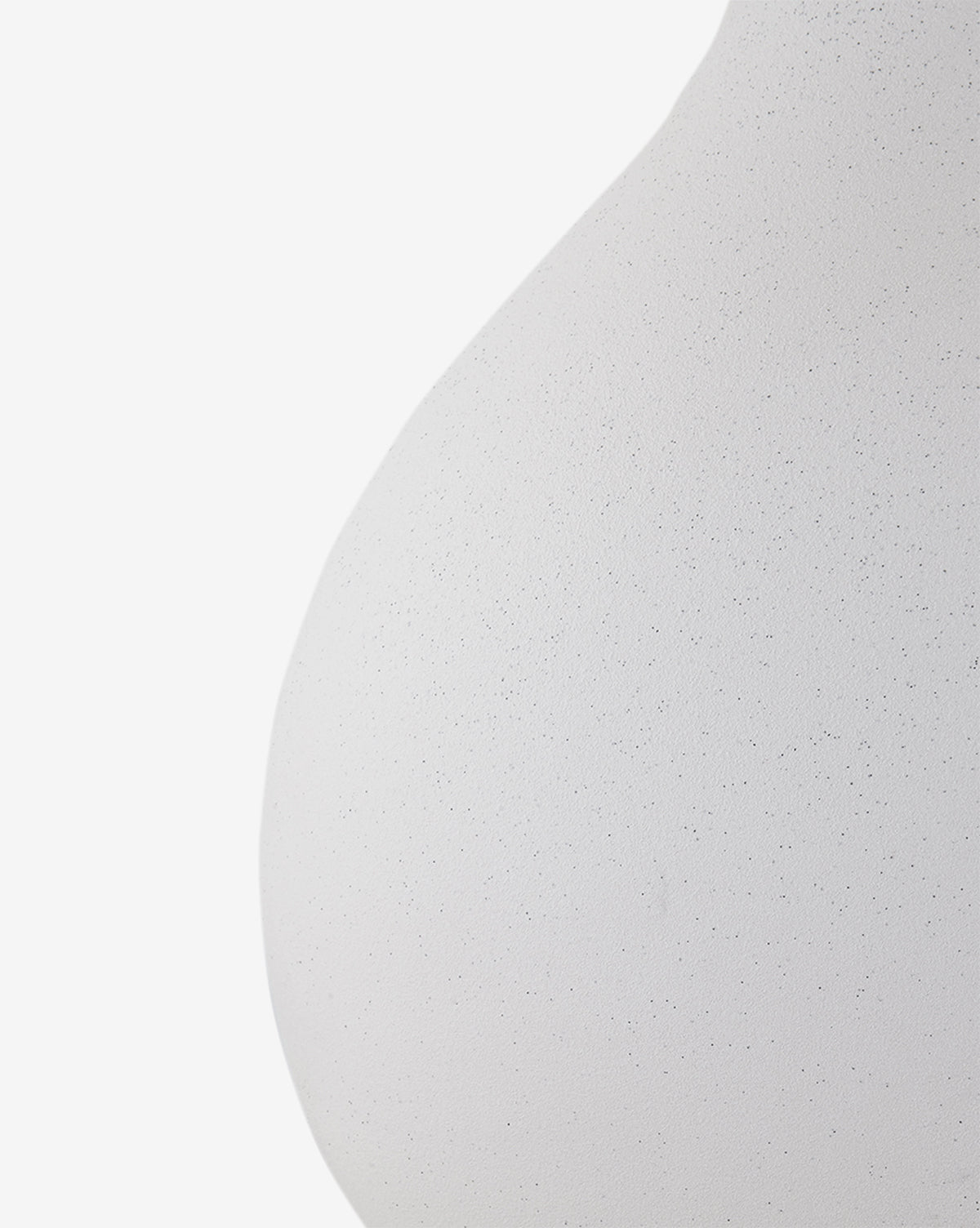 Close-up of the Helena Table Lamp’s smooth, rounded white ceramic base with a subtle speckled texture and a crisp white linen shade, shown against a plain background, by McGee & Co.
