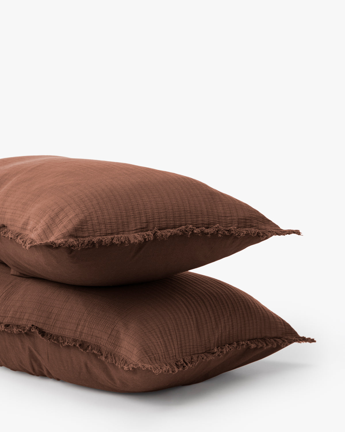 The Hendricks Chocolate Cotton Shams (Set of 2) showcase a brown checkered texture and fringed edges, adding 100% cotton comfort and style to your bedding against a plain white background.