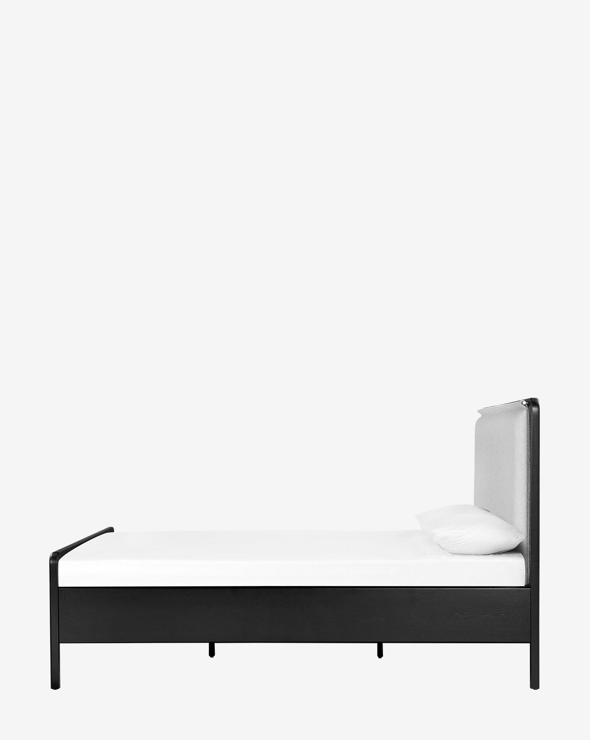 The Hensley Bed is shown in profile against a plain white background, featuring a sleek black frame, white mattress, single white pillow, and a stylish leather headboard for a modern minimalist look.