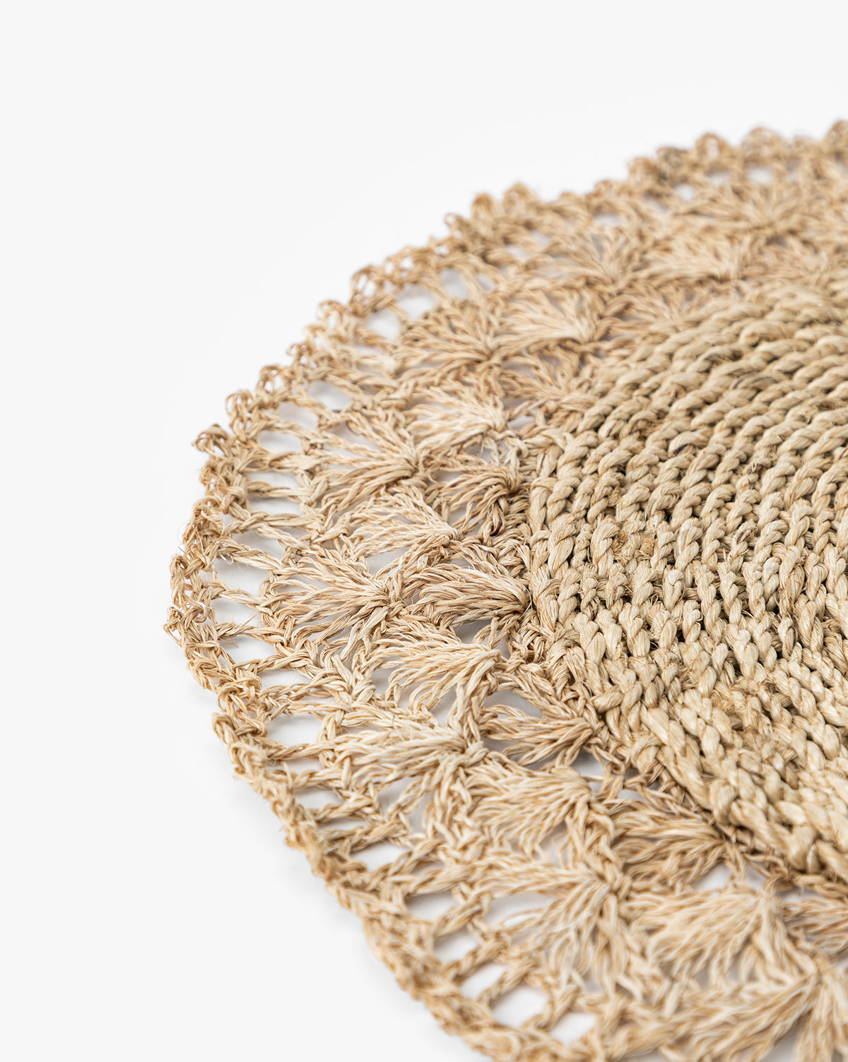 Close-up of the Hermione Placemat, a round design with an intricate, lacy crochet-inspired edge, set against a white background, by McGee & Co.