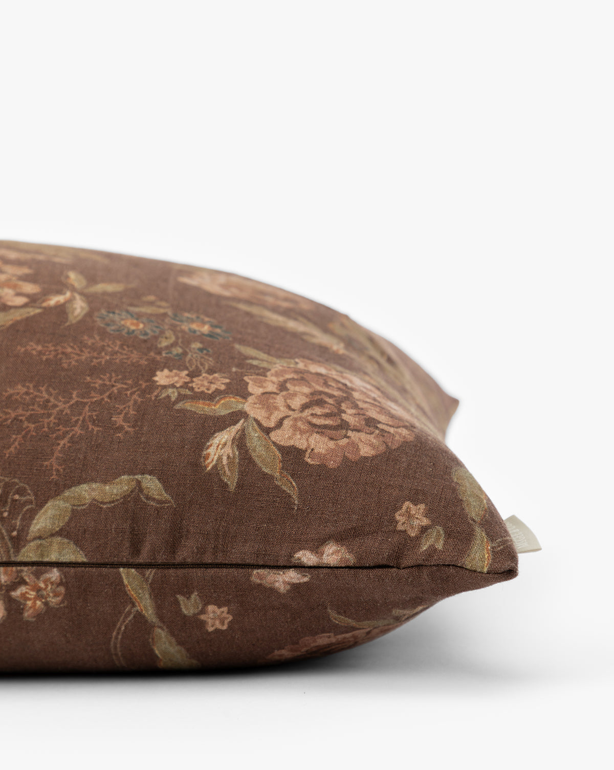 A close-up of the Hestercombe Pillow Cover, featuring a brown, vintage-inspired floral design in muted pink, green, and beige tones, displayed against a plain white background by McGee & Co.