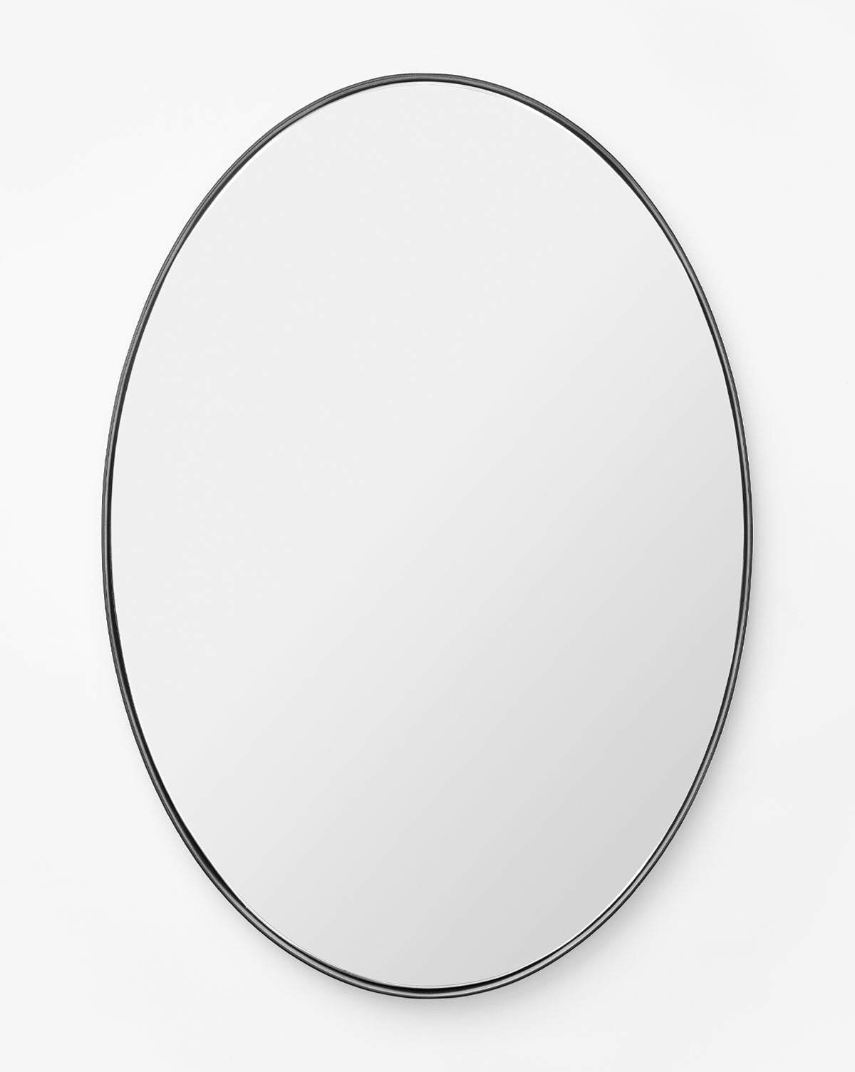 The Hogan Oval Mirror features a sleek stainless steel frame and is mounted on a plain white wall, reflecting a blank surface, by McGee & Co.