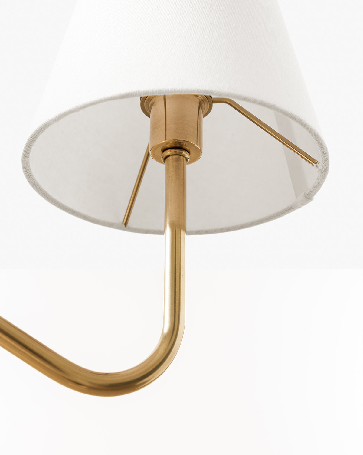 Close-up of the Holloway Floor Lamp in antique brass, featuring a white fabric shade and an elegant double-arm design with metal fittings, shown against a plain white background, by McGee & Co.