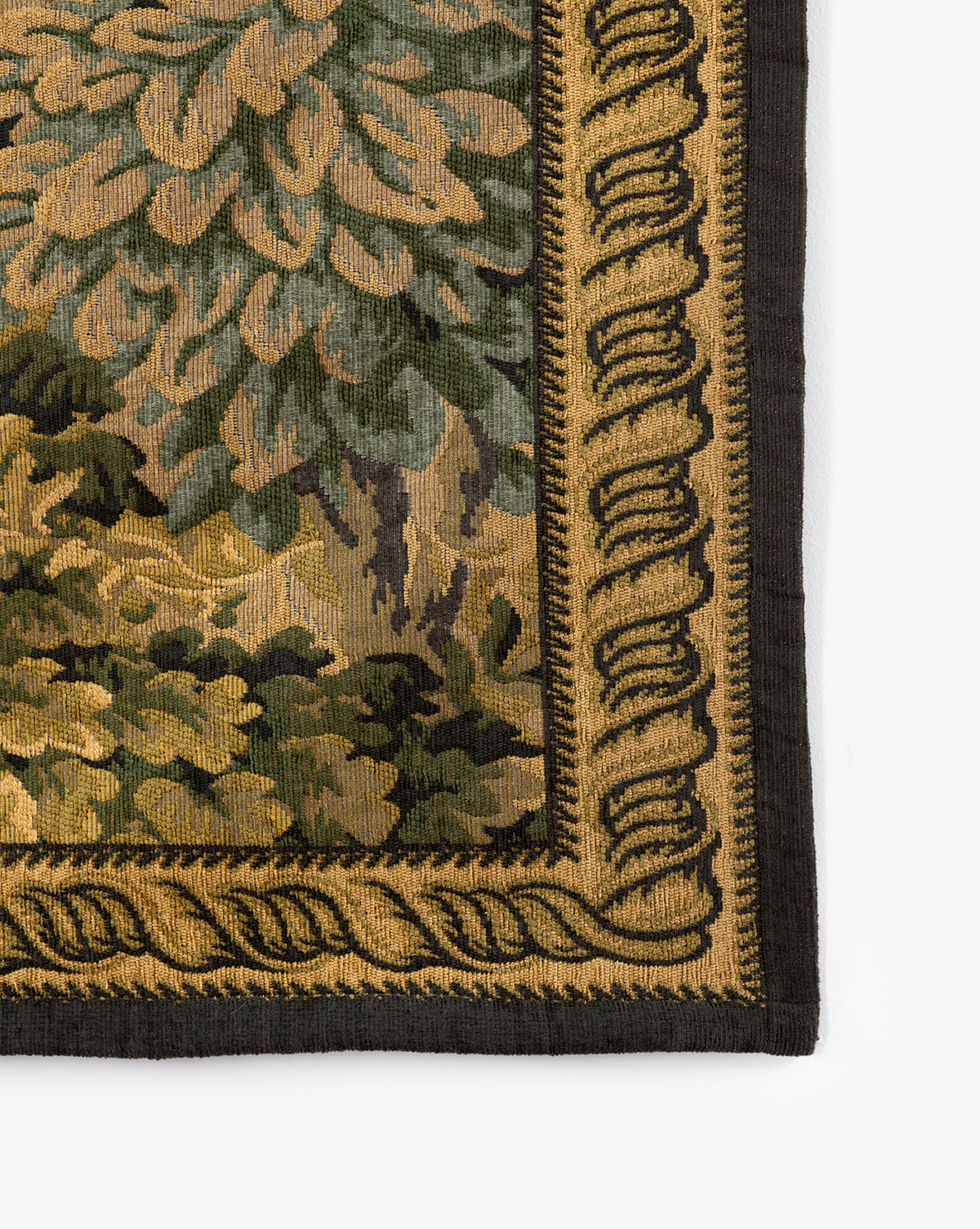 Close-up of the Hortensia Wall Tapestry corner, showcasing leafy green foliage in yellow and brown tones, framed by an ornate gold and black decorative border, by McGee & Co.