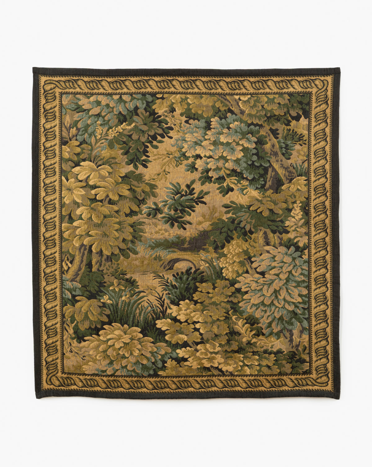 The Hortensia Wall Tapestry showcases a lush forest scene with dense green and gold foliage, trees, and a small stream, all framed by an intricate woven border, by McGee & Co.