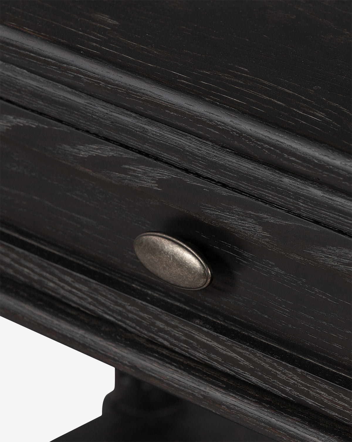 Close-up of the Humphrey Nightstand’s dark wooden drawer with a metallic oval handle, highlighting the wood grain texture and part of its sturdy, traditional supporting structure, by McGee & Co.