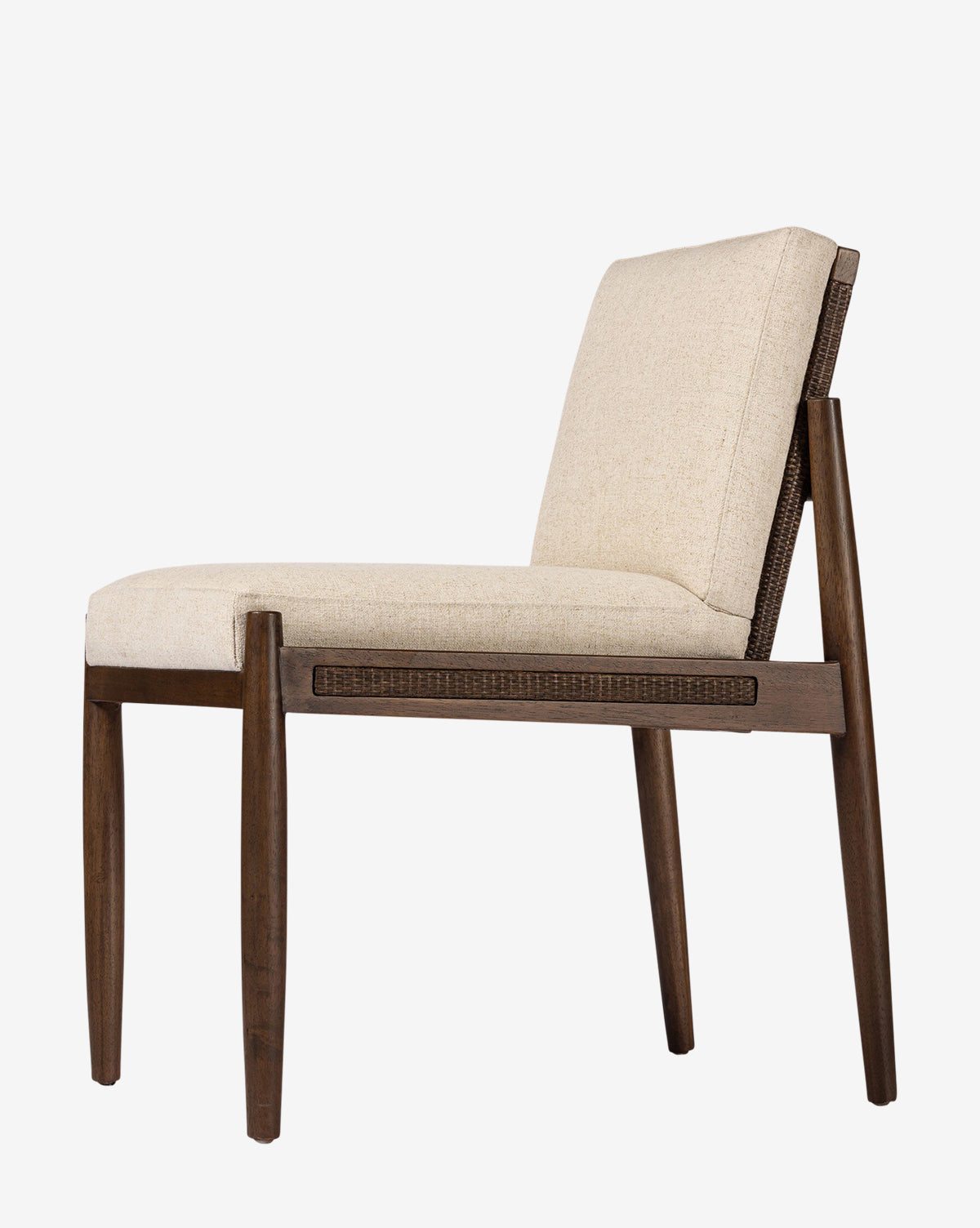 Side view of the Hurley Dining Chair with a cushioned seat and backrest in light beige performance upholstery, set on a dark wooden frame with subtly angled legs, shown against a plain white background, by McGee & Co.