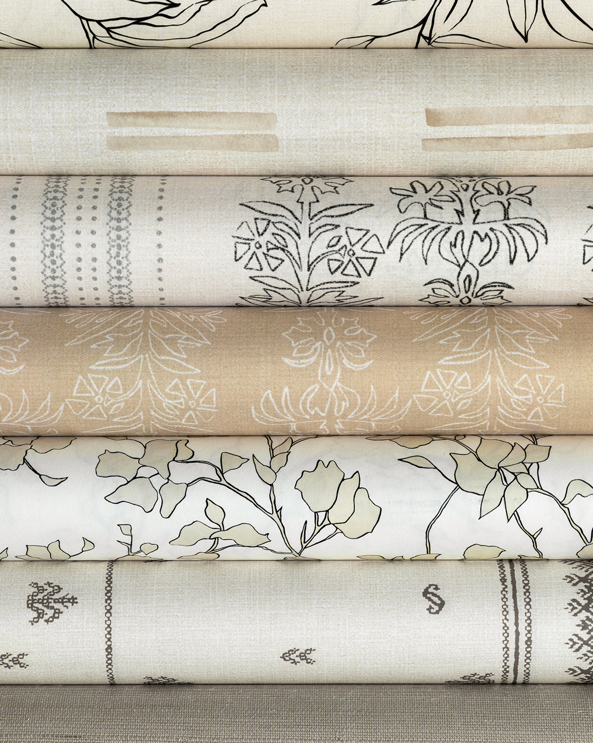 Six rolls of York Wallcoverings Blair Sketched Floral Wallpaper display cream, beige, and light brown tones with floral and geometric patterns—ideal for a soft, nursery-inspired look. McGee & Co.