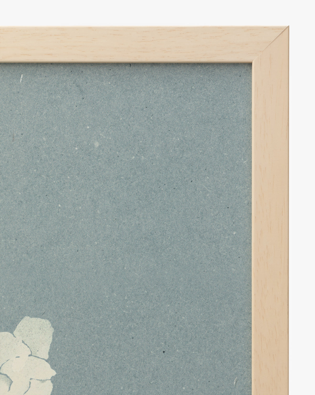 A close-up of the top right corner of the Iris Ink Block shows a wooden frame, blue background, and white floral design—perfect wall art to brighten up childrens room decor, by McGee & Co.