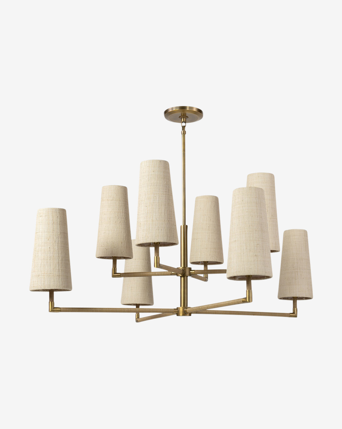 The Irving Chandelier by Palecek features a brass frame, leather-wrapped poles, and eight beige fabric drum shades in two tiers, all descending from a matching brass ceiling mount for a modern look. McGee & Co.