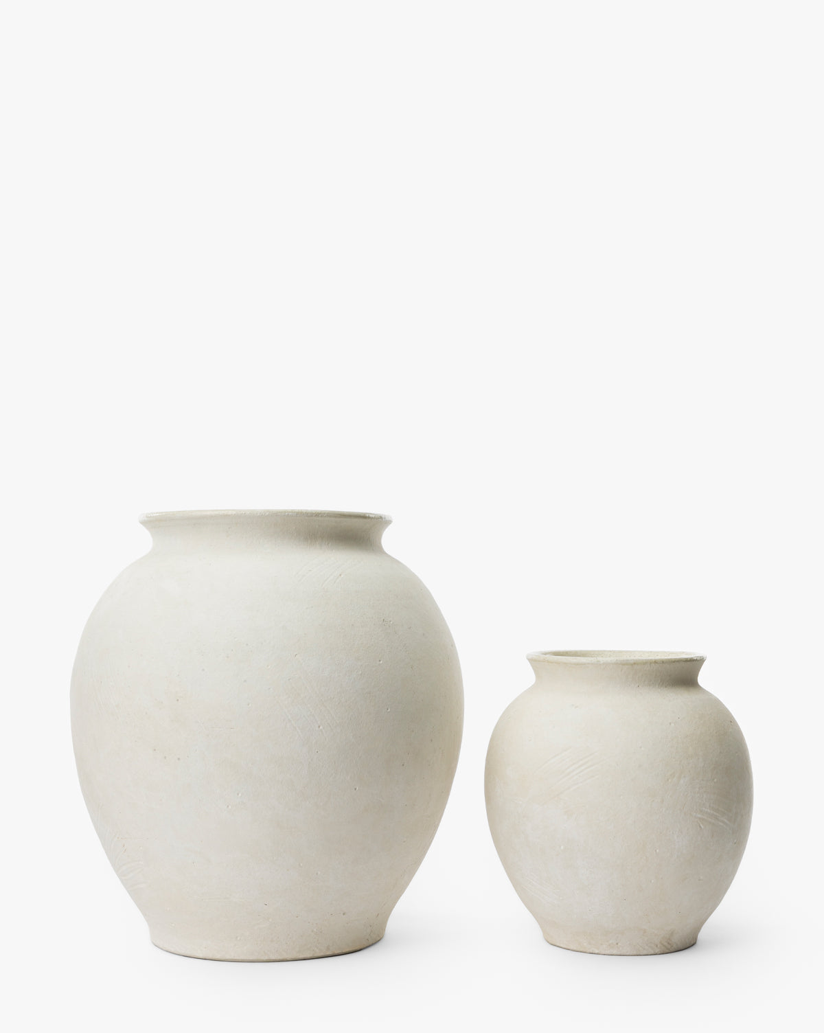 Two round Isla Terracotta Vases in different sizes, featuring smooth, off-white ceramic surfaces, are displayed side by side against a white background—perfect for adding understated elegance to your home decor, by McGee & Co.