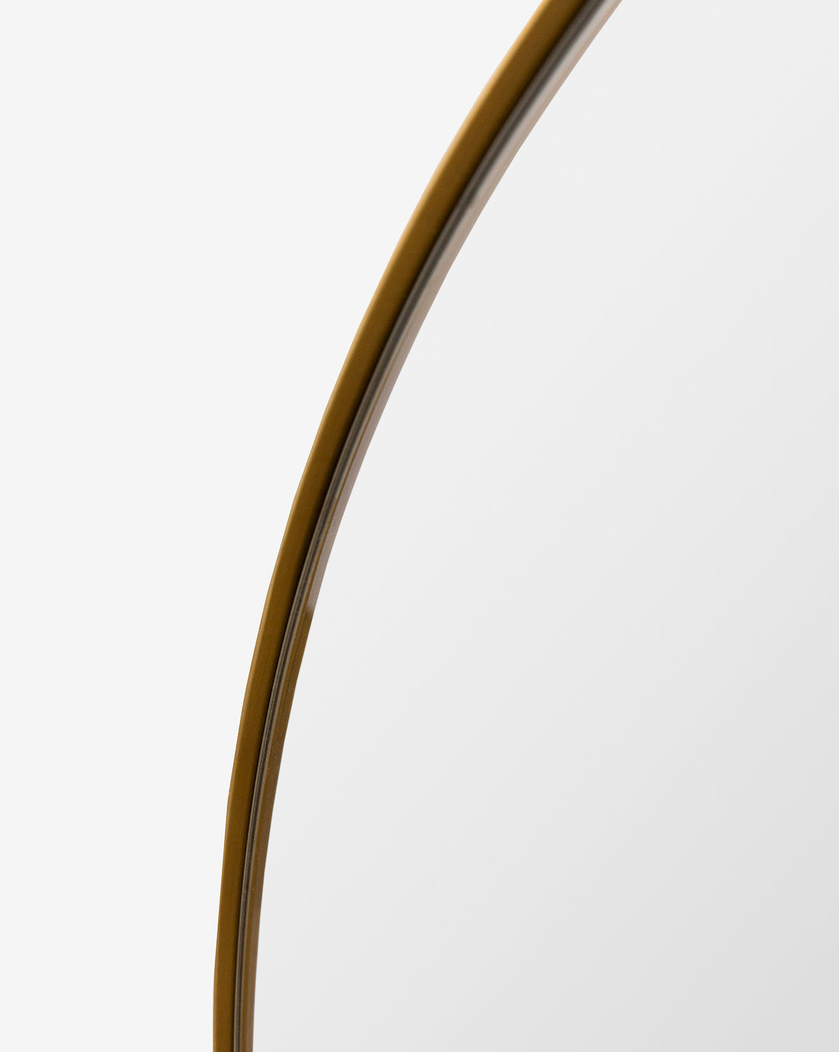 A detailed look at the Jace Inset Circle Mirrors thin gold metal frame, set against a plain white background, by McGee & Co.