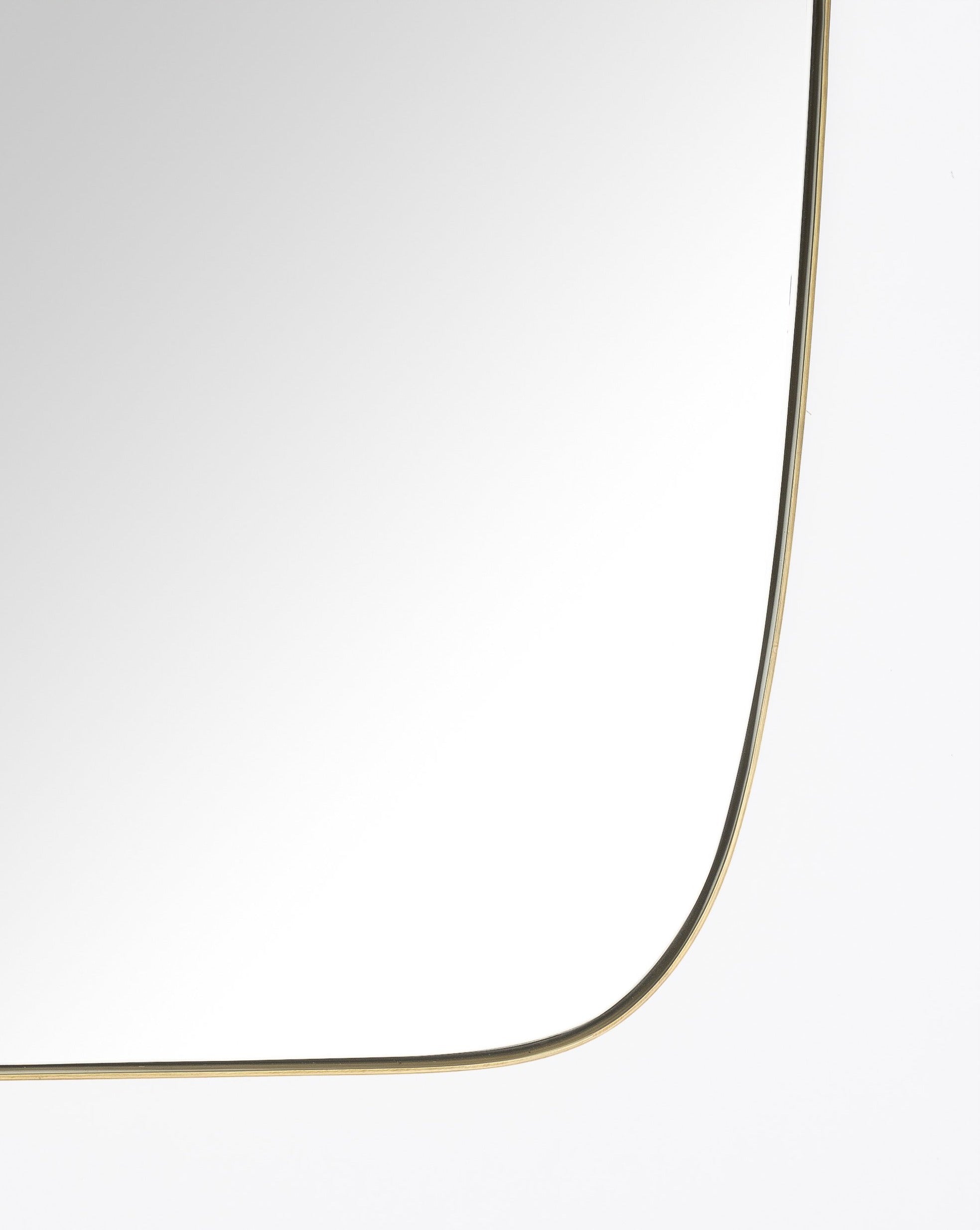 A close-up of the Jace Inset Mirror highlights its slim, gold stainless steel frame and rounded corner, set against a plain white background, by McGee & Co.