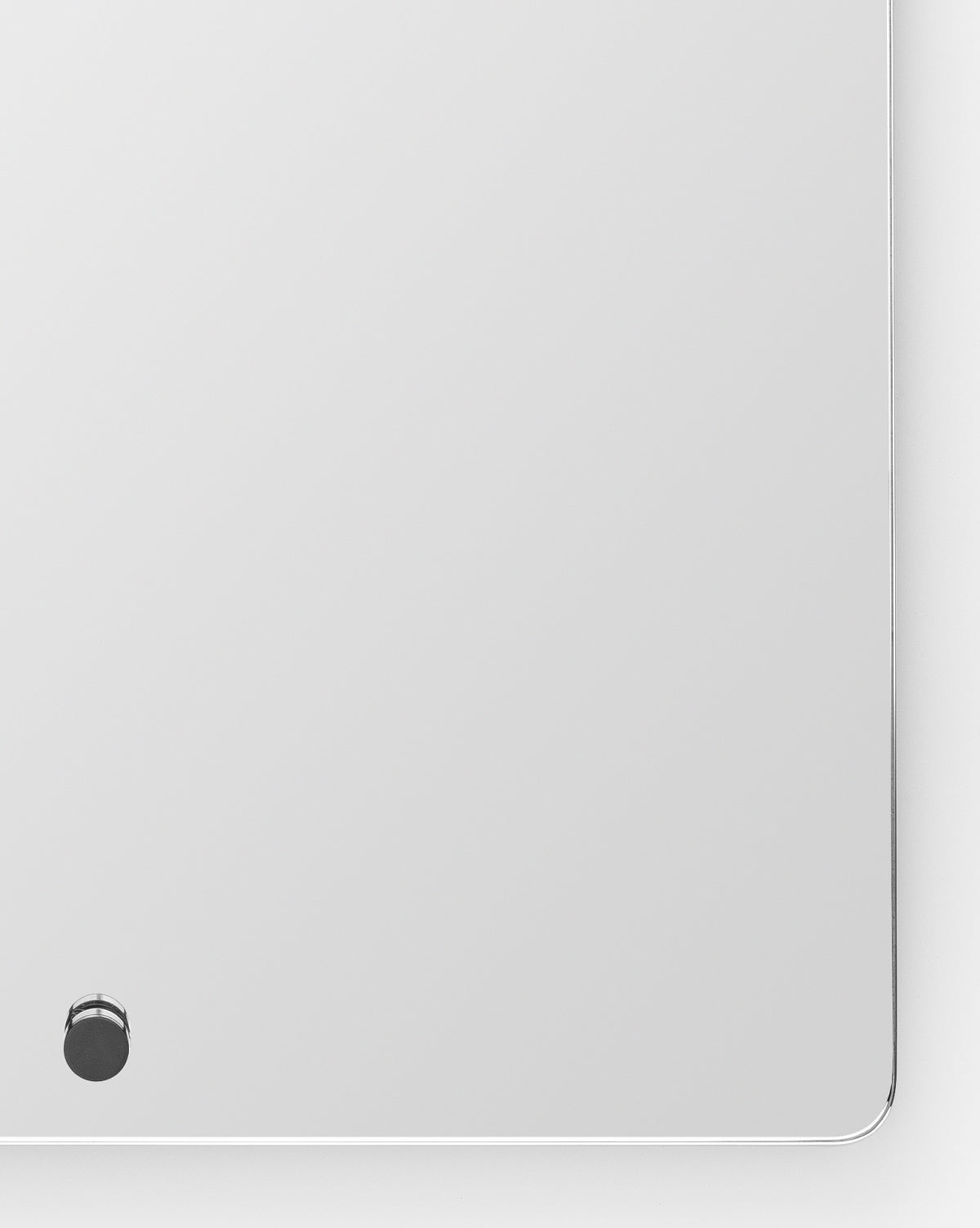 The Jacob Rectangular Mirror features a minimalist design with rounded corners, a small round black button near the bottom left, slightly beveled edges, and a brass frame—ideal as an entryway mirror for modern spaces, by McGee & Co. Plain white background.