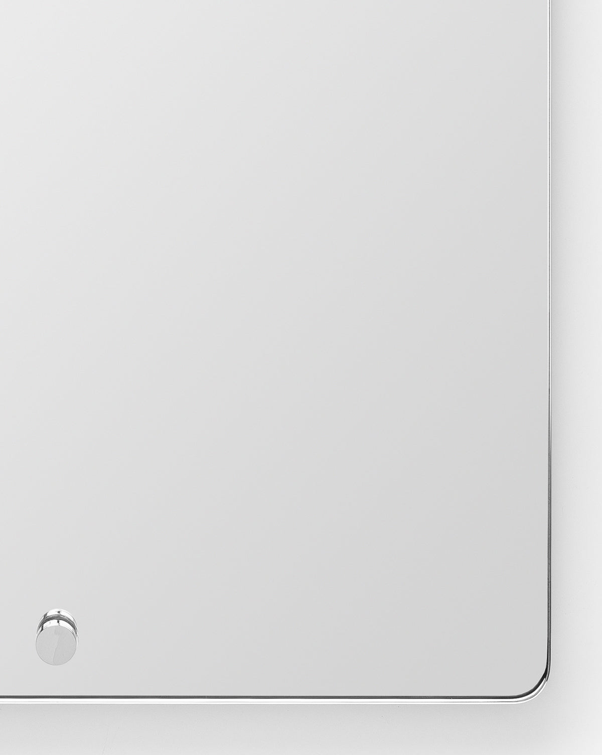 The Jacob Rectangular Mirror has rounded corners, a slim brass frame, and a small round knob at the lower left. Ideal for entryways, it features a clean design and beautifully reflects its surroundings by McGee & Co.