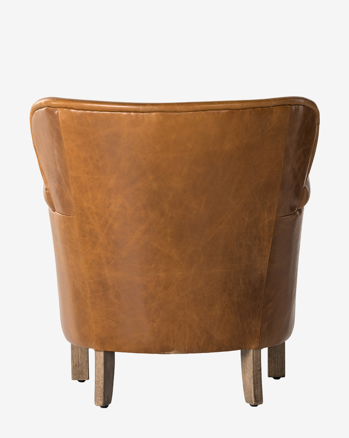 The Jarah Lounge Chair is shown from behind, featuring brown top-grain leather, a curved silhouette, and four wooden legs against a plain white background, by McGee & Co.