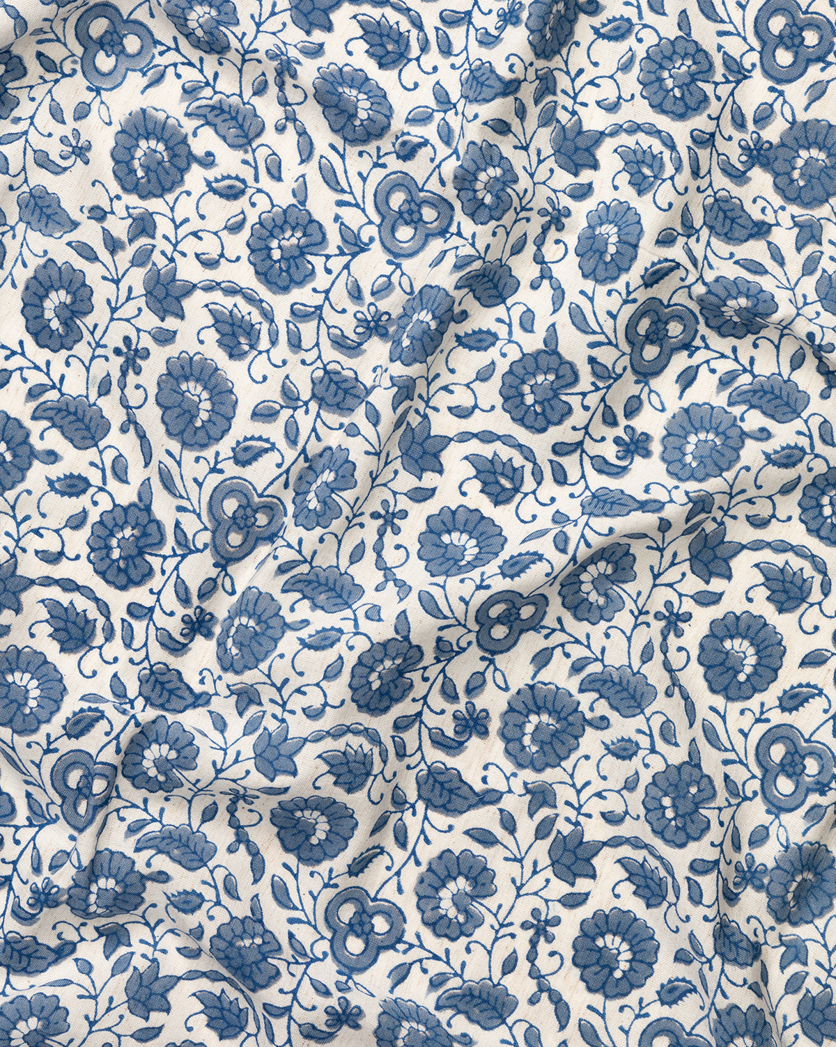 The Jennie Tablecloth features a white fabric with an intricate blue floral pattern of flowers, leaves, and vines, by McGee & Co.