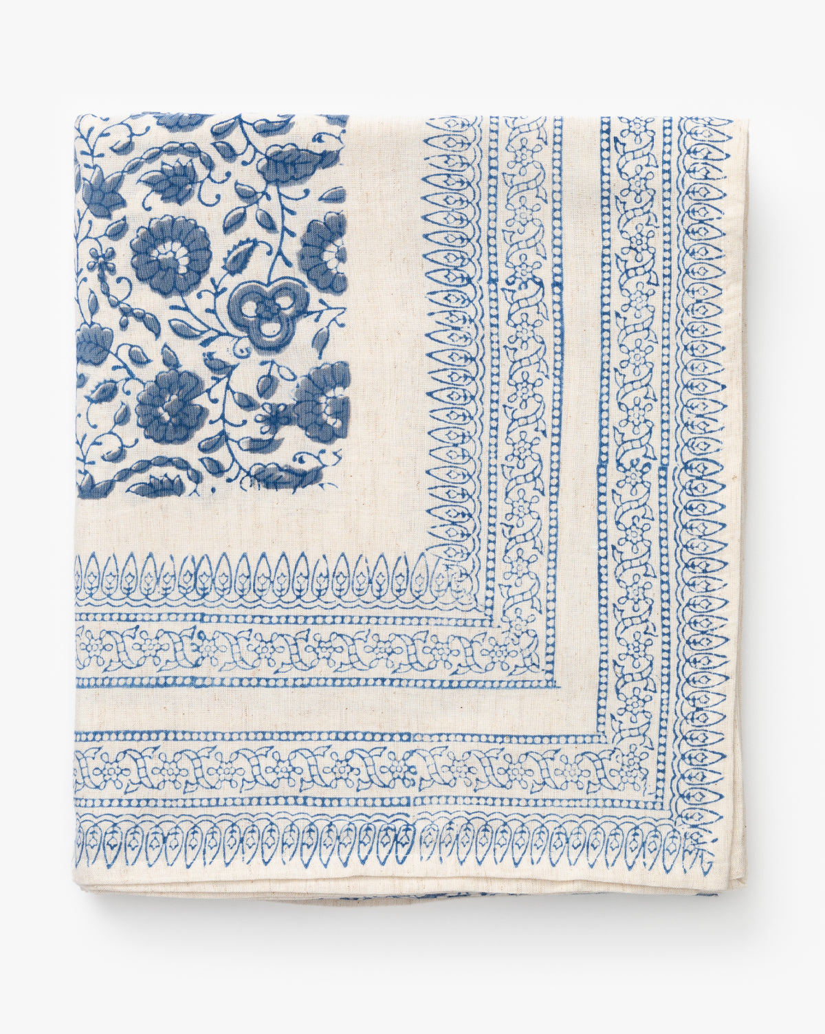 The Jennie Tablecloth is a folded, cream-colored tablecloth with intricate blue floral block prints and detailed geometric borders, shown on a white background by McGee & Co.