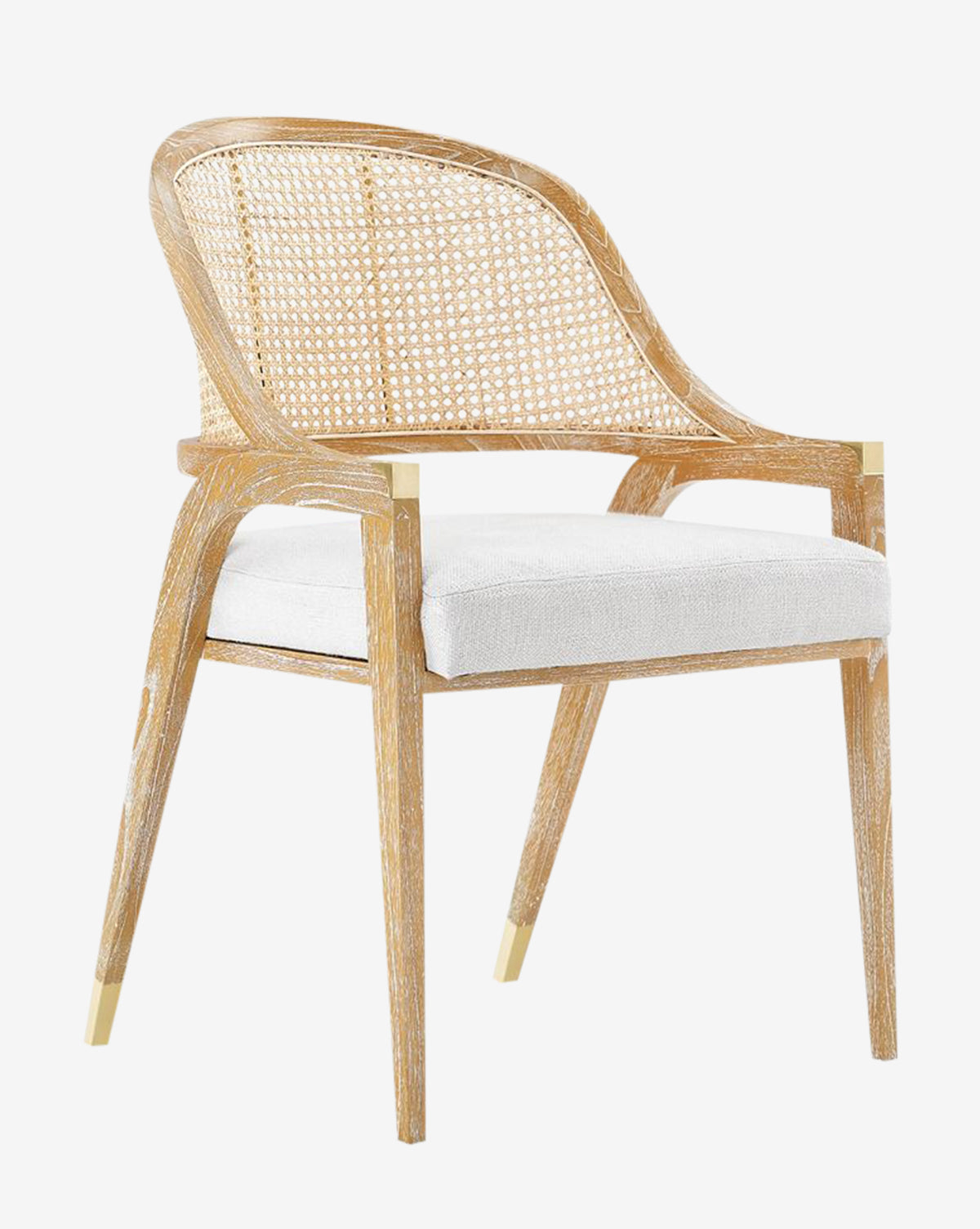 The Jensen Dining Chair showcases a modern look with a hand-woven cane back, white cushioned seat, and angled Cape Lilac Mahogany legs finished with gold-colored metal caps, by McGee & Co.