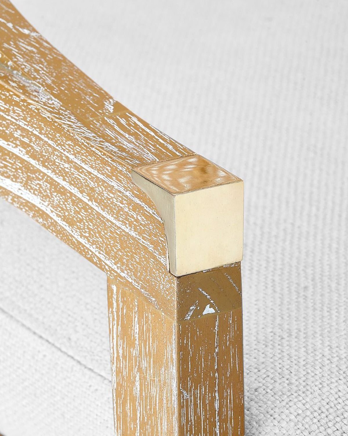 Close-up of the Jensen Counter Stool’s solid Cape Lilac Mahogany frame with a distressed finish and visible grain, joined to a beige upholstered cushion for rustic character, by McGee & Co.