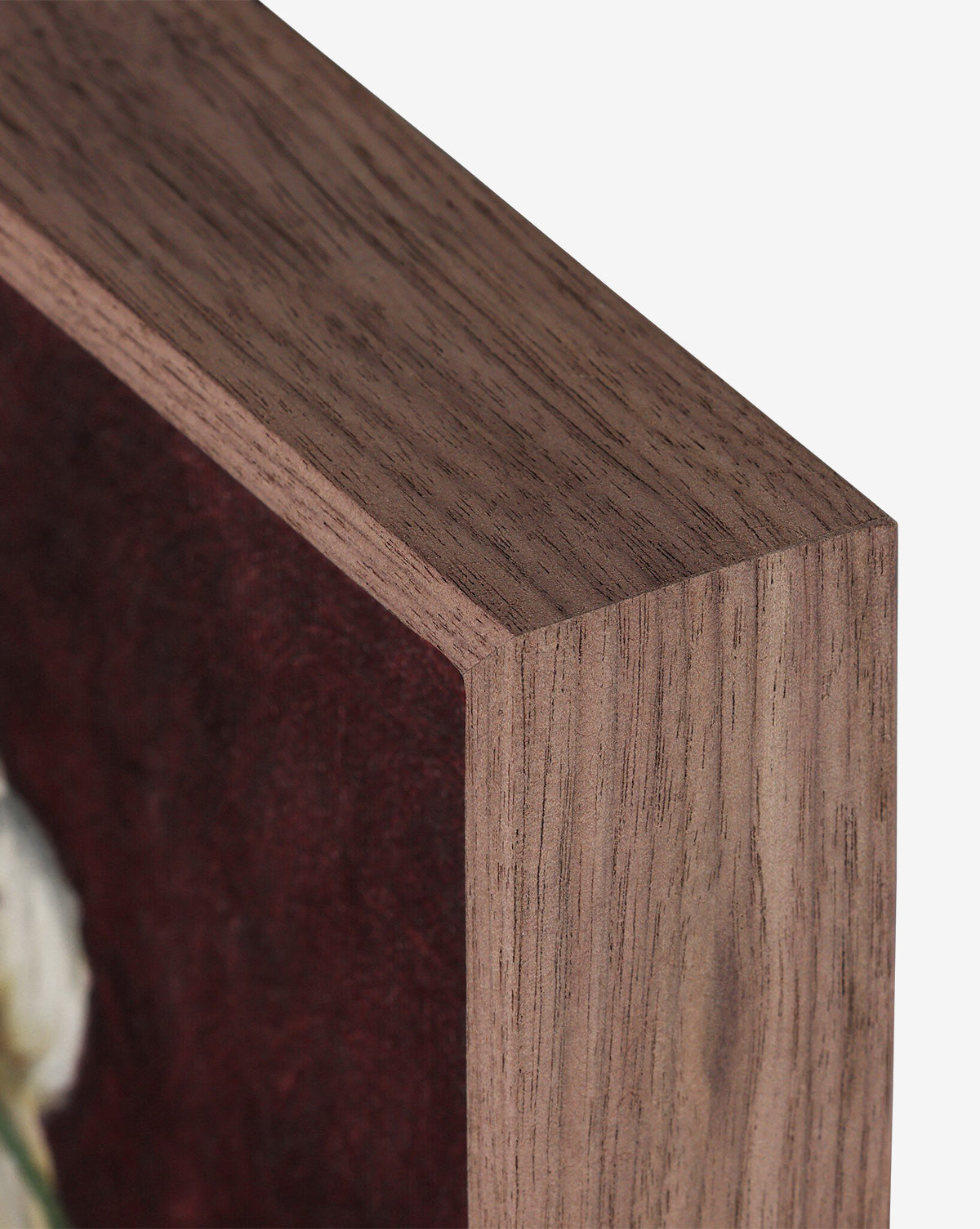 Close-up of a walnut-finish wooden frame, handmade in Austin, displaying Jubilee by Bethany Joseph with part of a burgundy and white artwork visible inside, by McGee & Co.