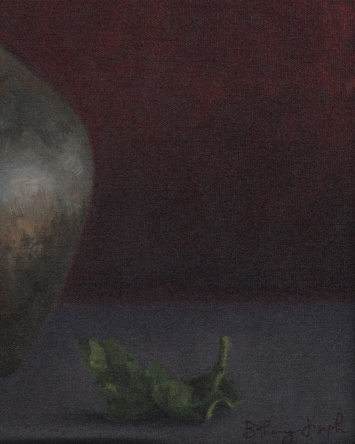 A single green leaf rests beside the curved edge of Jubilee by Bethany Joseph, a handmade metallic pot crafted in Austin, set against a deep red background with soft lighting that evokes a moody, contemplative atmosphere, by McGee & Co.