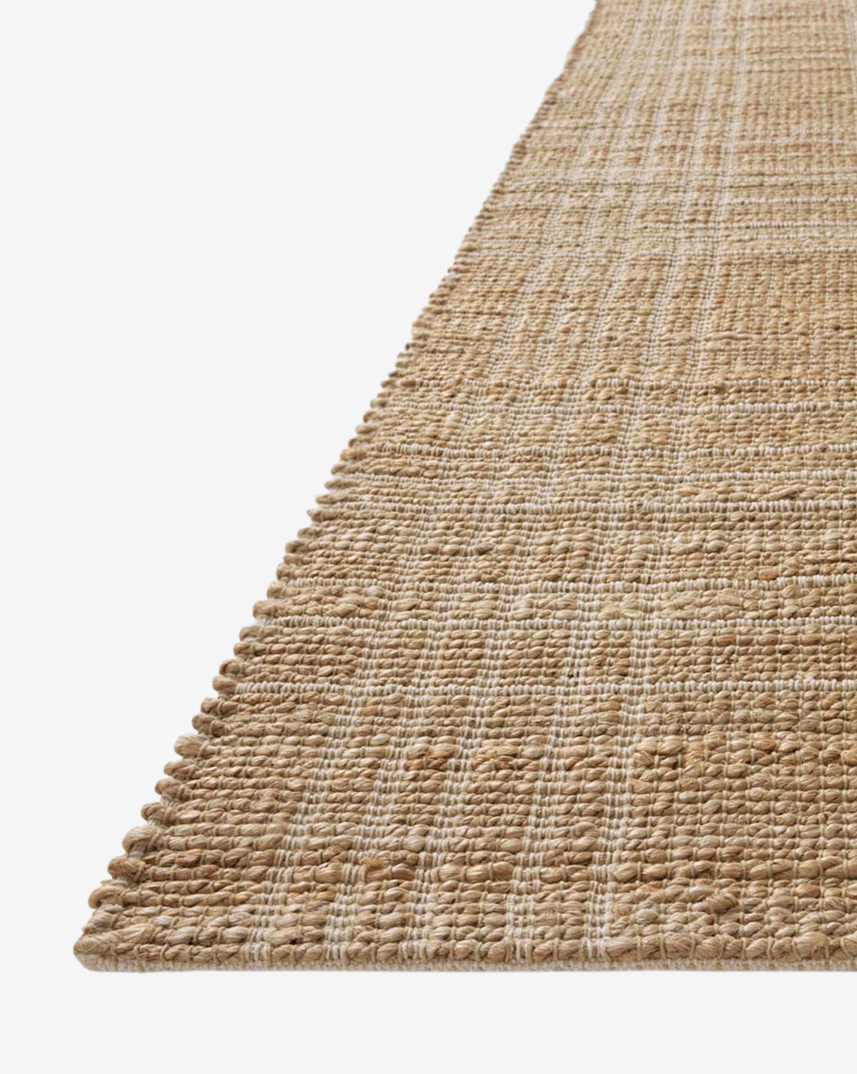A close-up angled view of the Judy Jute Rug Collection No. 1, a handwoven jute rug with a subtle checkered pattern in beige and tan, set against a white background, by McGee & Co.