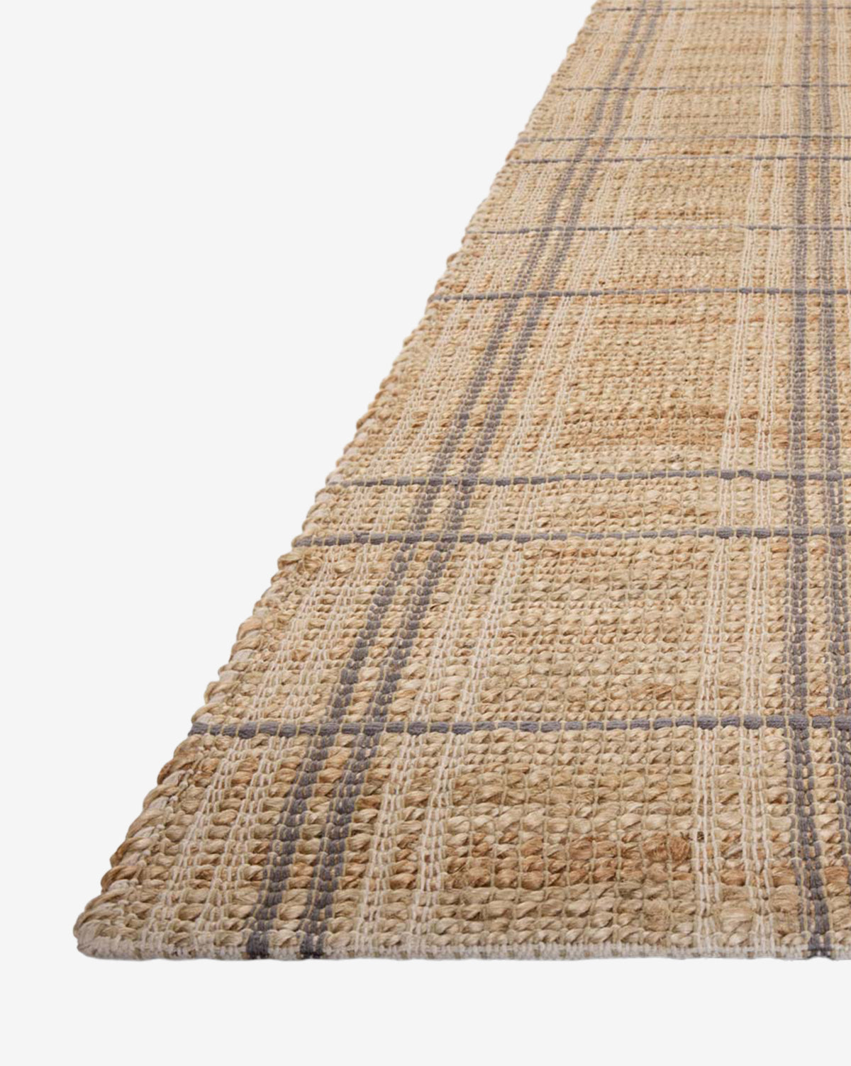 The Judy Jute Rug Collection No. 2 is a handwoven rug with a plaid pattern in natural tan, beige, and gray tones, displayed at an angle on a white background, by McGee & Co.