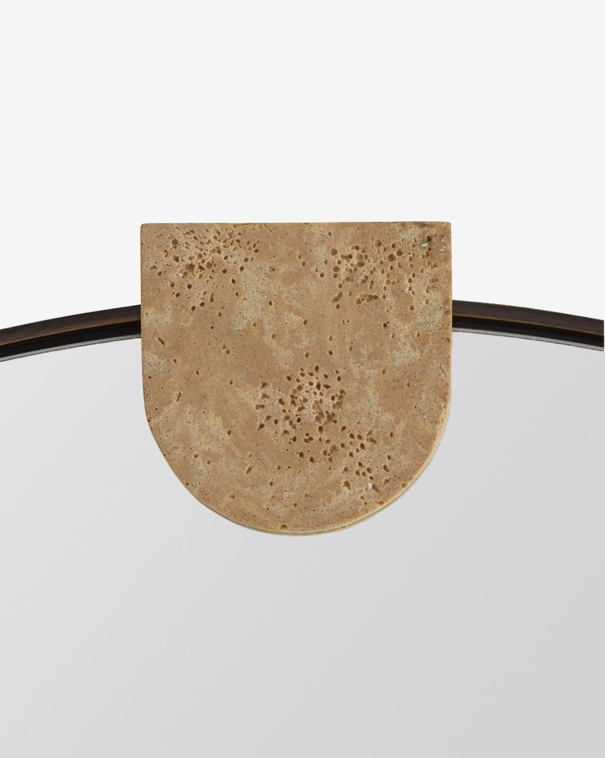 A close-up of the Kairos Mirror, showcasing its round shape with a semi-circular faux travertine accent on top and a natural, textured finish, by McGee & Co.