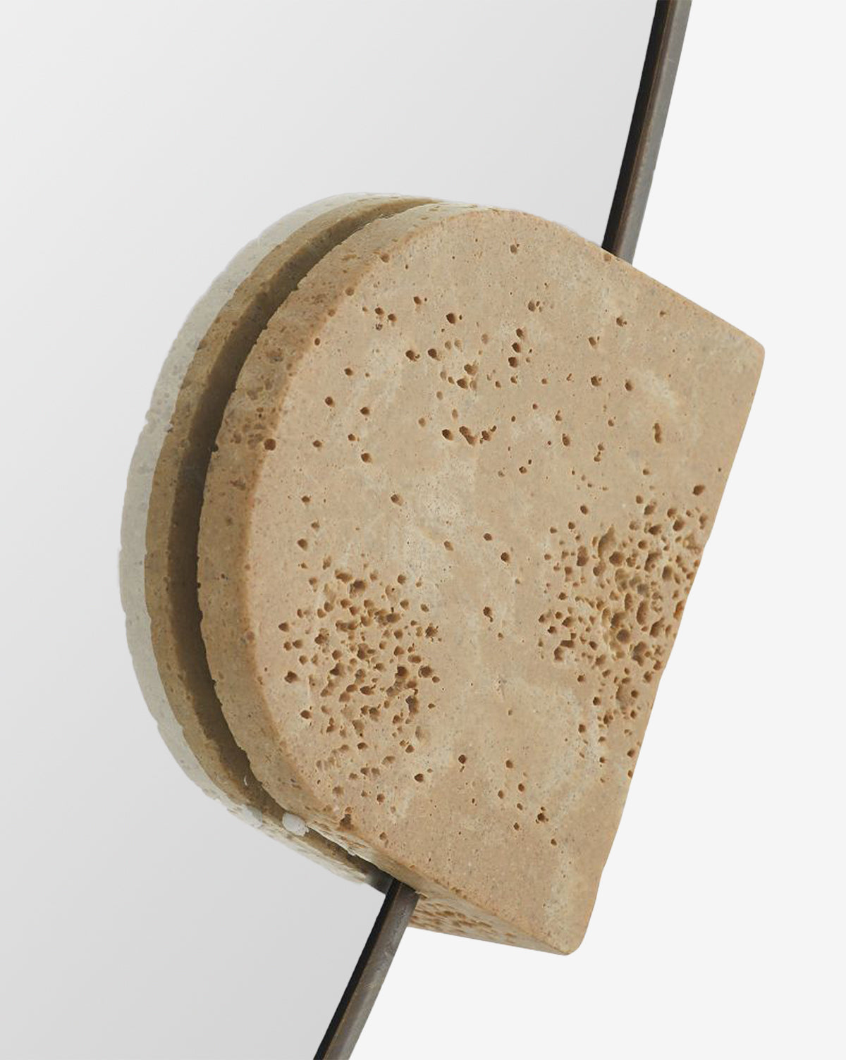 Close-up of the Kairos Mirror, featuring a textured faux travertine support holding the glass edge, set against a plain white background, by McGee & Co.