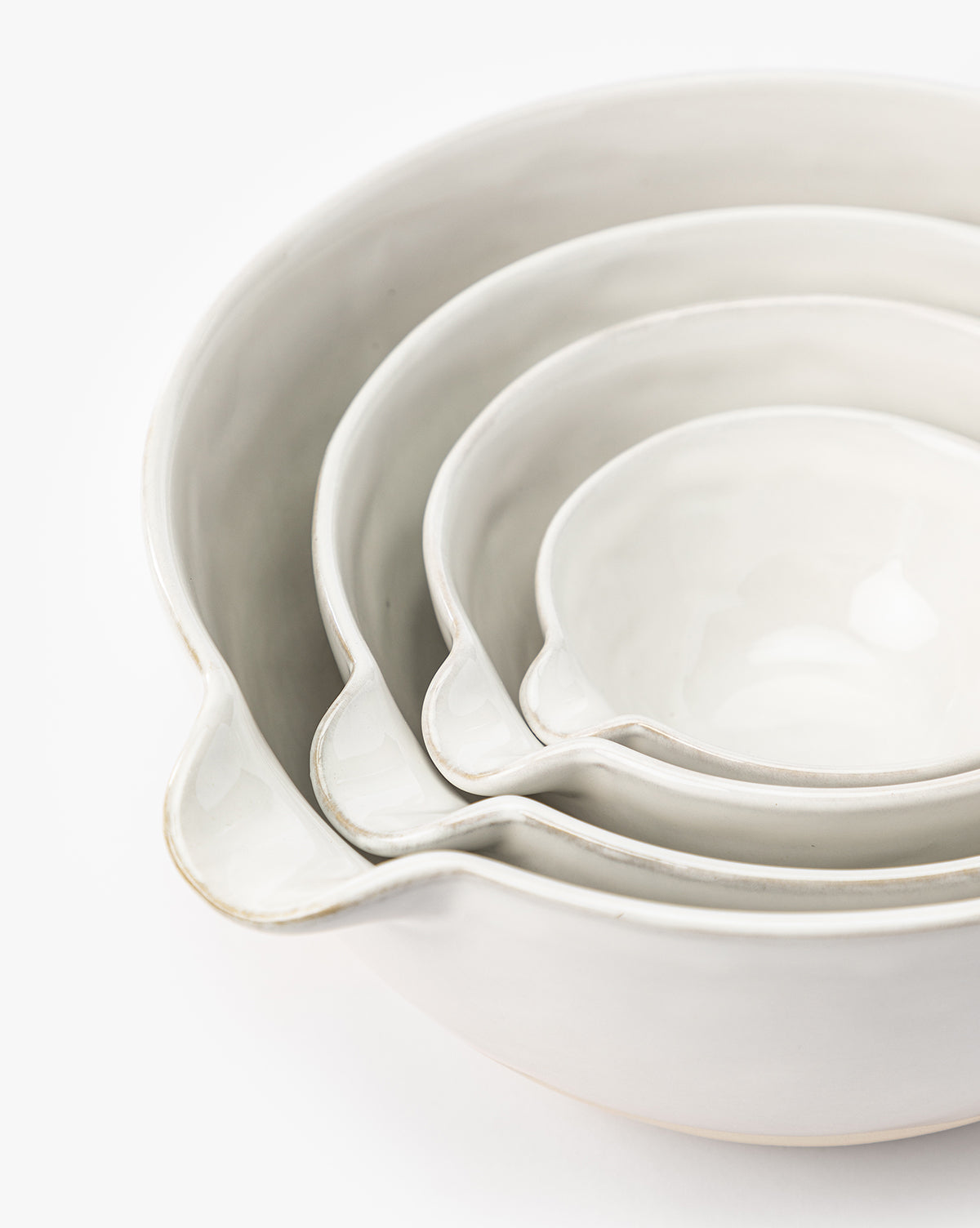 The Karina Stoneware Batter Bowls (Set of 4) nest together in graduated sizes, each featuring a pouring spout and subtle vintage baking charm, displayed against a white background, by McGee & Co.