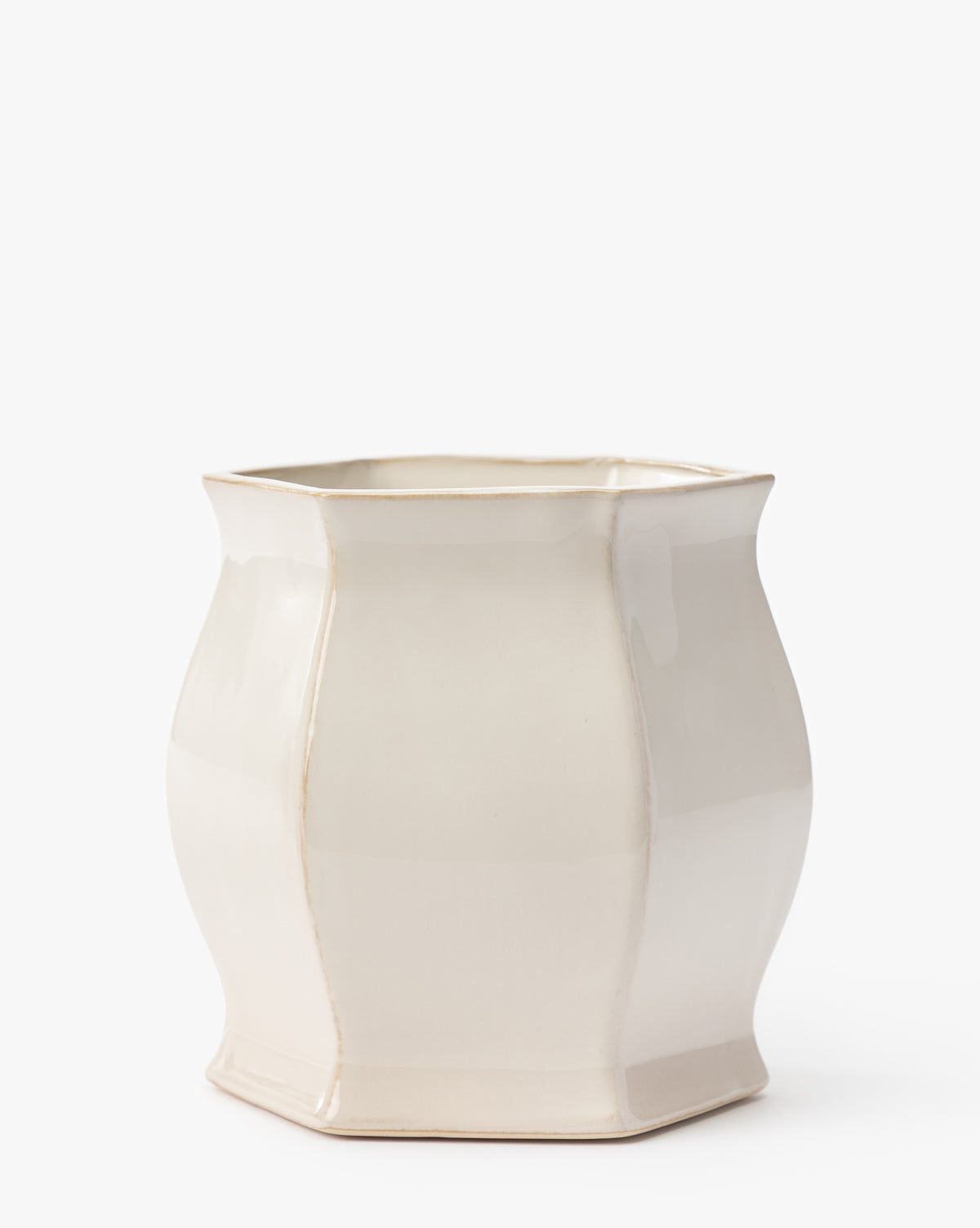 The Kasha Cream Pot by Napa Home & Garden features a glossy, cream ceramic finish, soft curves with gentle vertical ridges, and a flared hexagonal shape for an artisan-quality minimalist look by McGee & Co.