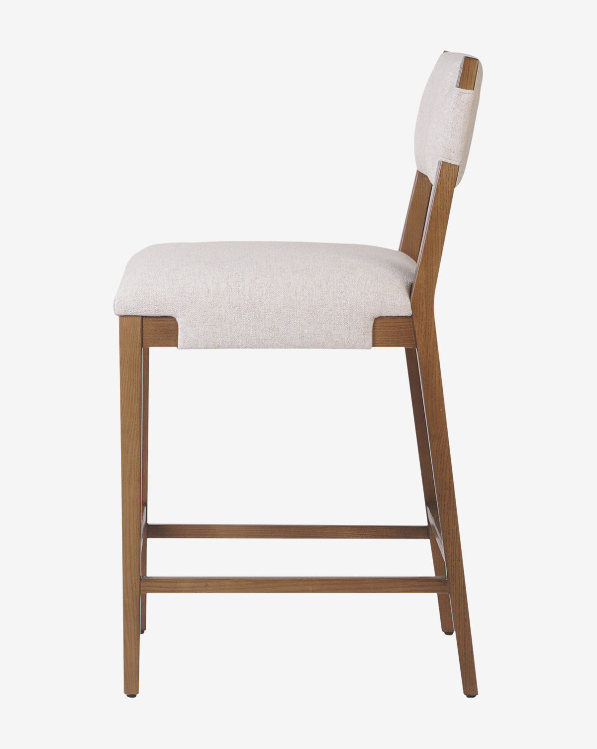 The Kennebec Stool by Four Hands features an ash frame, beige performance fabric seat and backrest, a footrest bar, and a sleek modern design—making it a stylish addition to any kitchen from McGee & Co.