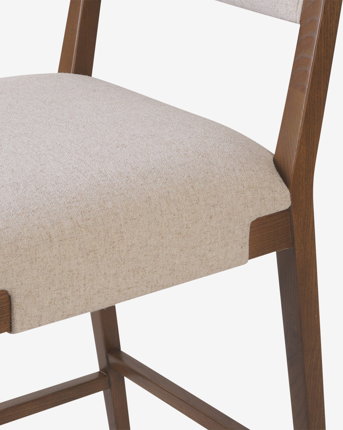 Close-up of the Four Hands Kennebec Stool, featuring a light beige performance fabric seat and backrest on an ash frame. The white background highlights the stool’s design and craftsmanship. McGee & Co.