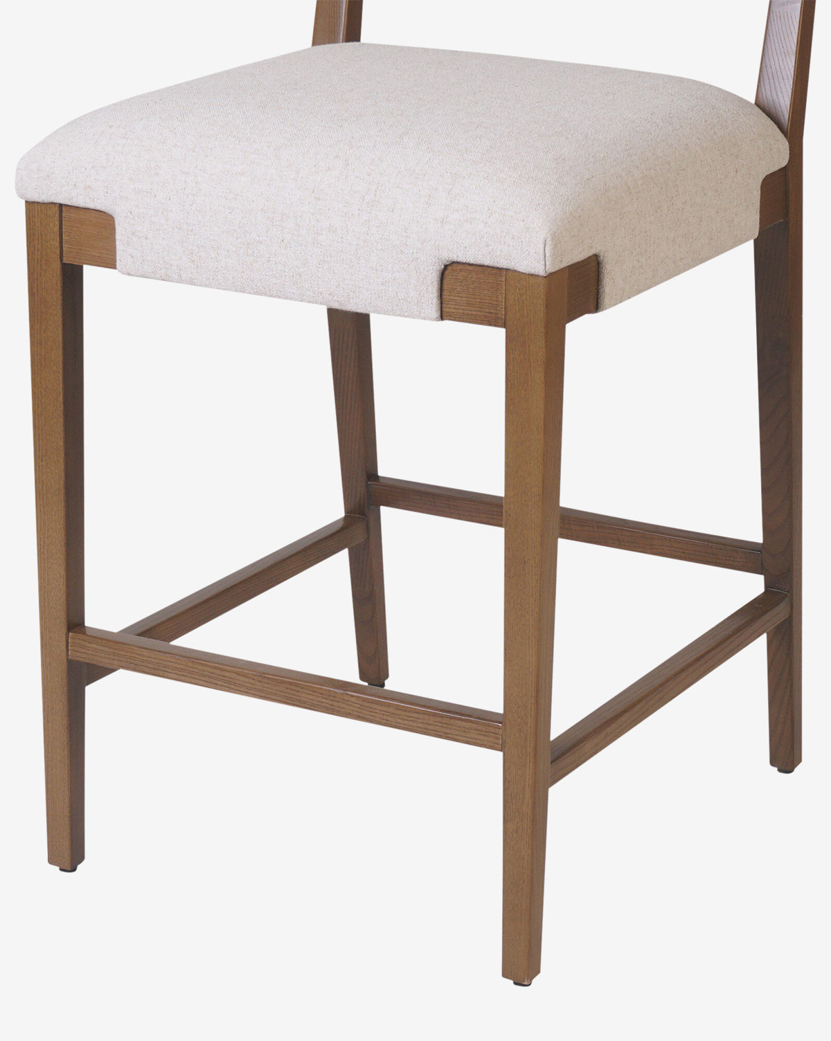 The Kennebec Stool by Four Hands features a close-up of its ash wood frame, straight legs with horizontal supports, and a light beige performance fabric upholstered seat. McGee & Co.