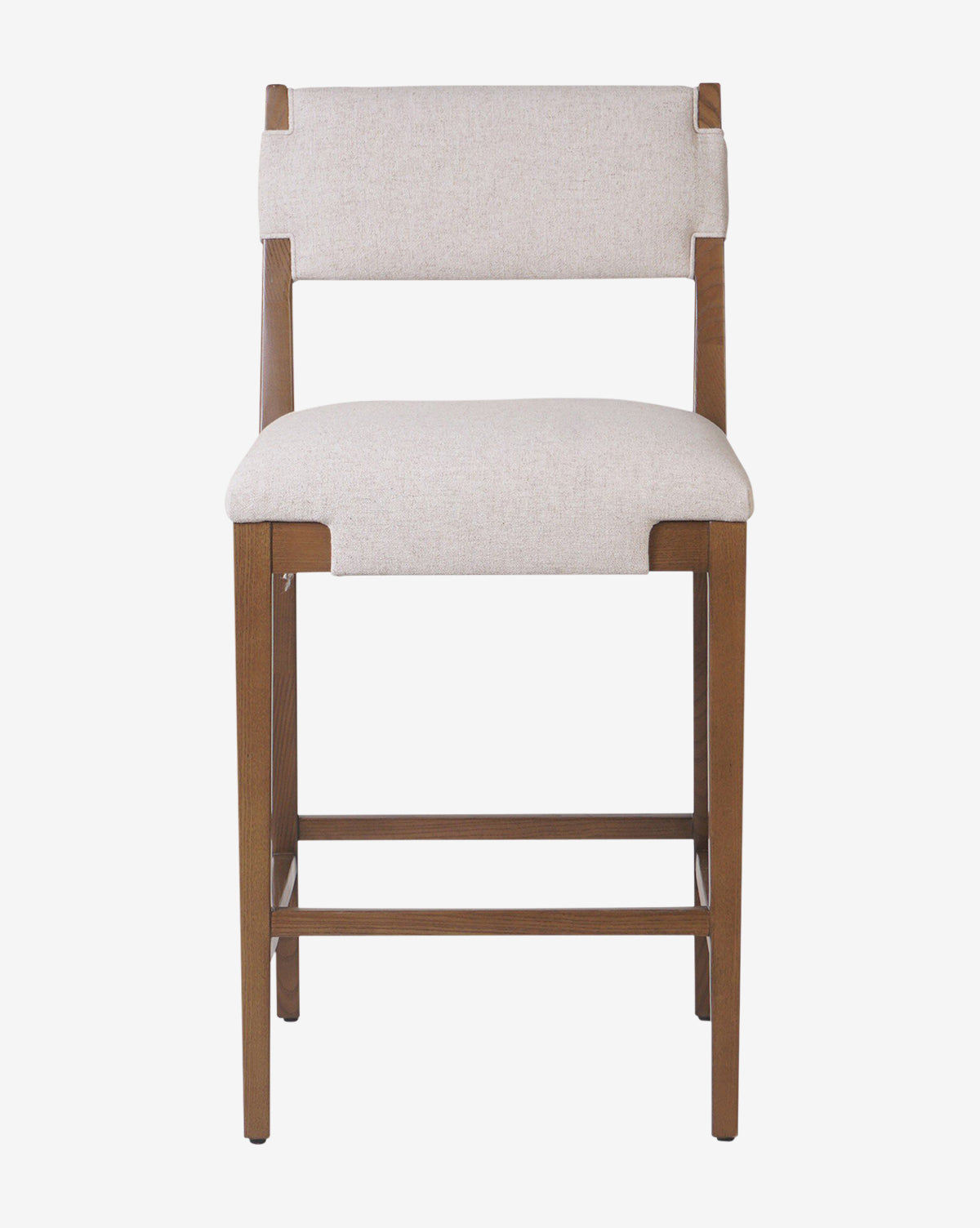 The Kennebec Stool by Four Hands is a wooden kitchen stool with straight legs and footrests, featuring a rectangular design and light beige performance fabric upholstery on the seat and backrest, shown against a plain white background. McGee & Co.