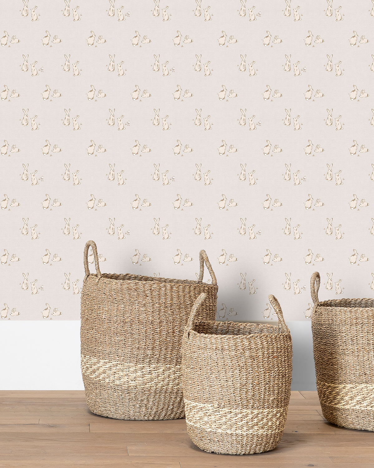 Wallpaper in pastel tones with whimsical bunny pairs on a gray backdrop for a charming nursery by McGee & Co.