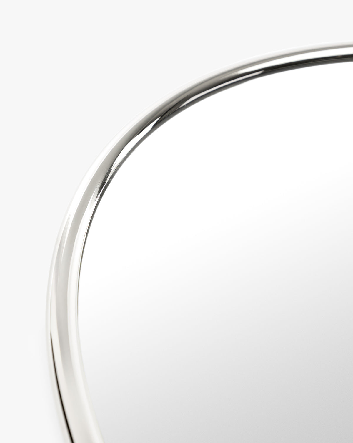 A close-up of the Kitson Oval Mirror highlights its sleek, antique brass oval frame set against a plain white background, by McGee & Co.