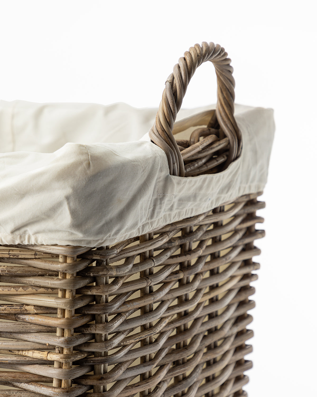 A close-up of the Kobo Wheeled Basket, featuring a twisted handle, white fabric liner, and woven wicker design, set against a white background.