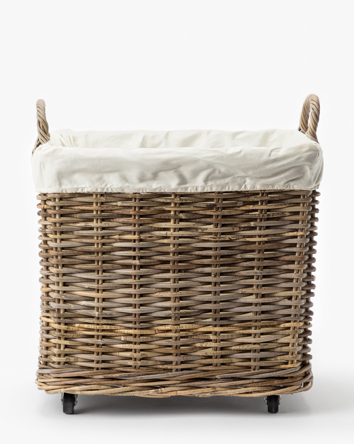 The Kobo Wheeled Basket is a rectangular rattan laundry basket featuring two handles, a white fabric liner, and small wheels for easy mobility, shown against a plain white background.