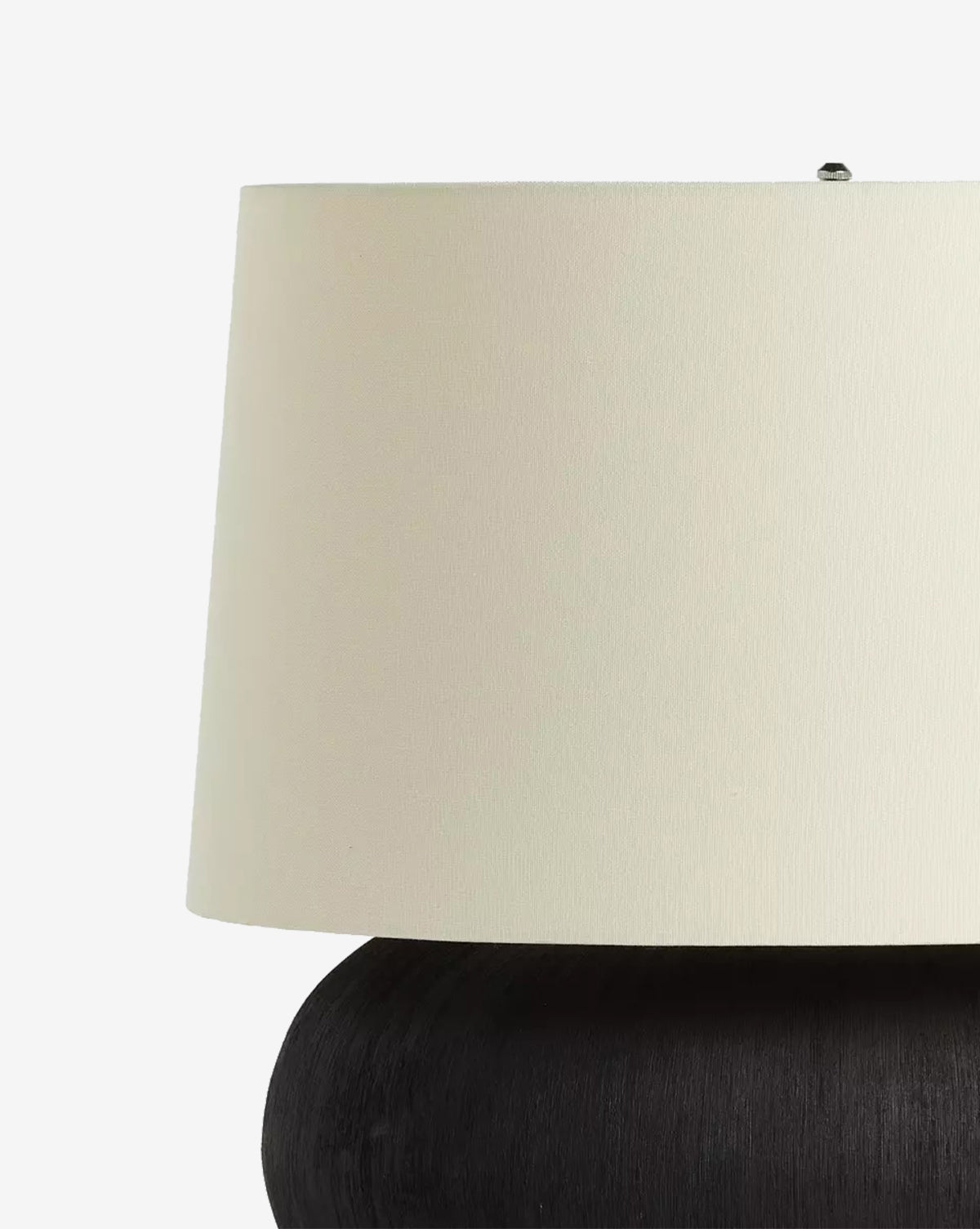 A close-up of the Kragen Table Lamp highlights its ivory linen shade and round dark ceramic base, set against a plain white background, by McGee & Co.