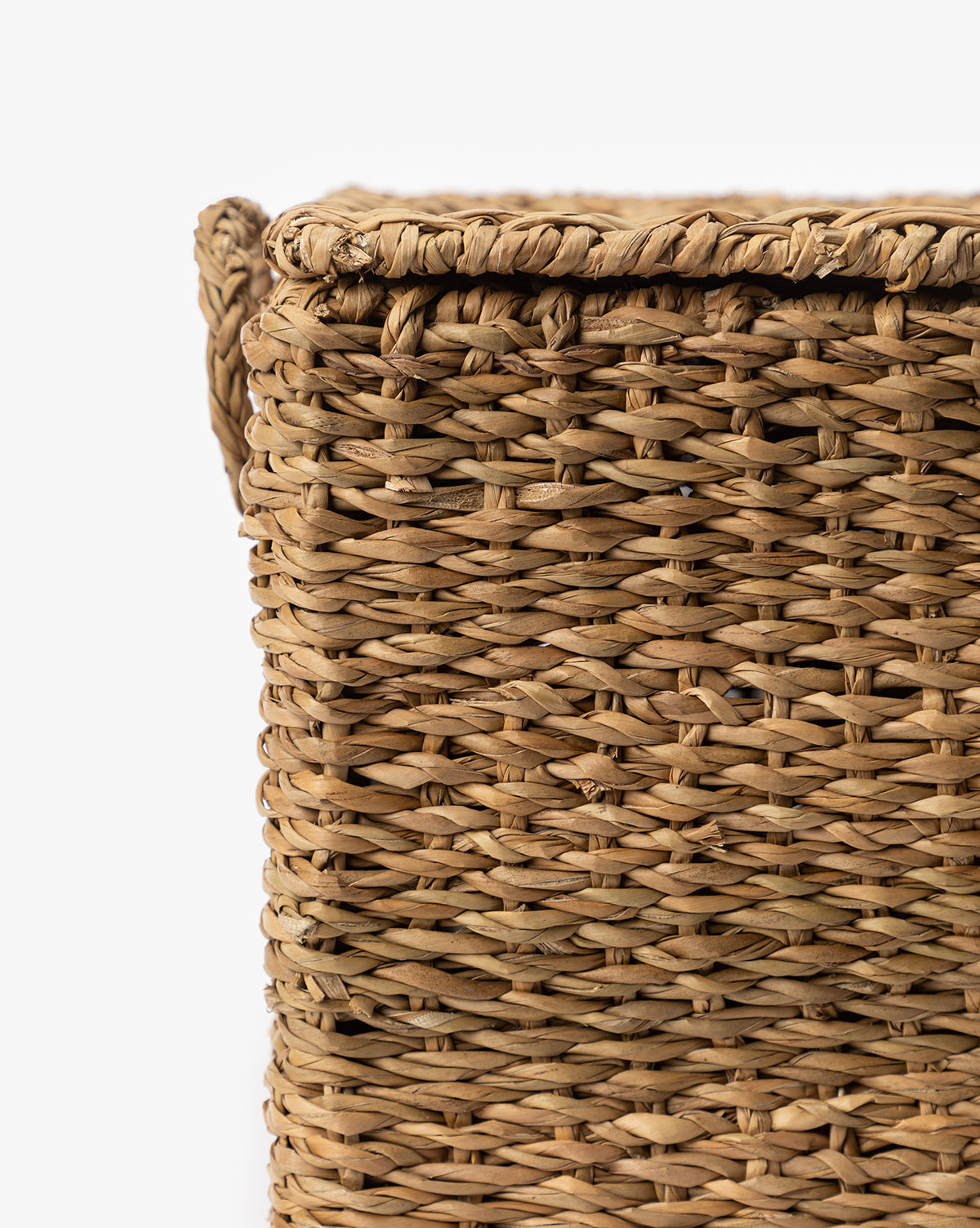 Close-up of the upper corner of the Kya Seagrass Box, showcasing its hand-woven texture and intricate pattern, set against a white background, by McGee & Co.