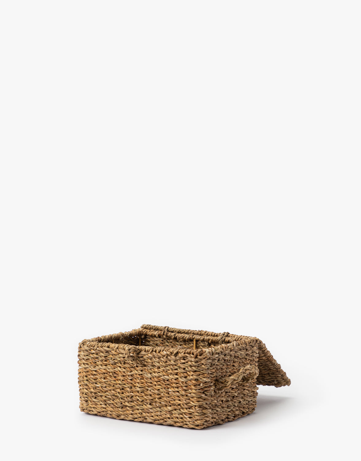 The Kya Seagrass Box, a small hand-woven rectangular storage box with a hinged lid, is shown partially open on a white background by McGee & Co.