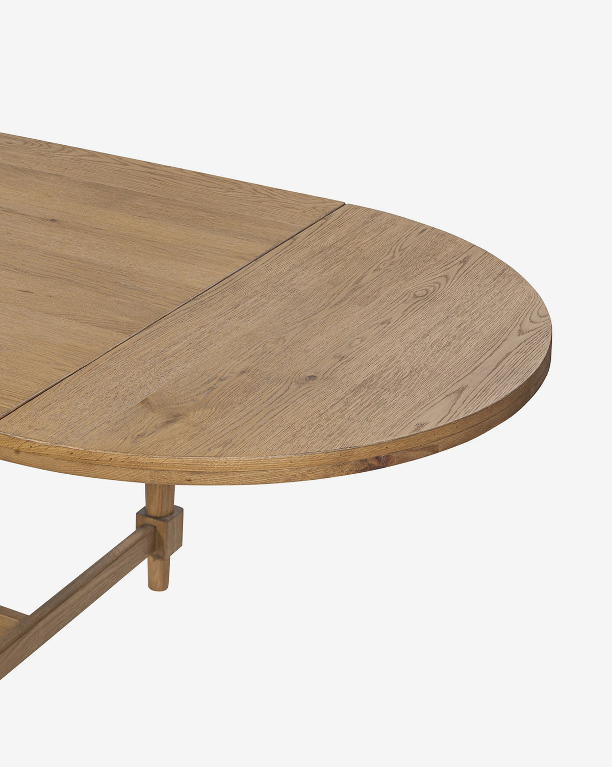 A close-up of the Kyler Oak Extension Dining Table showcases the join between its rectangular and rounded sections, featuring a light natural finish and visible wood grain, by McGee & Co.