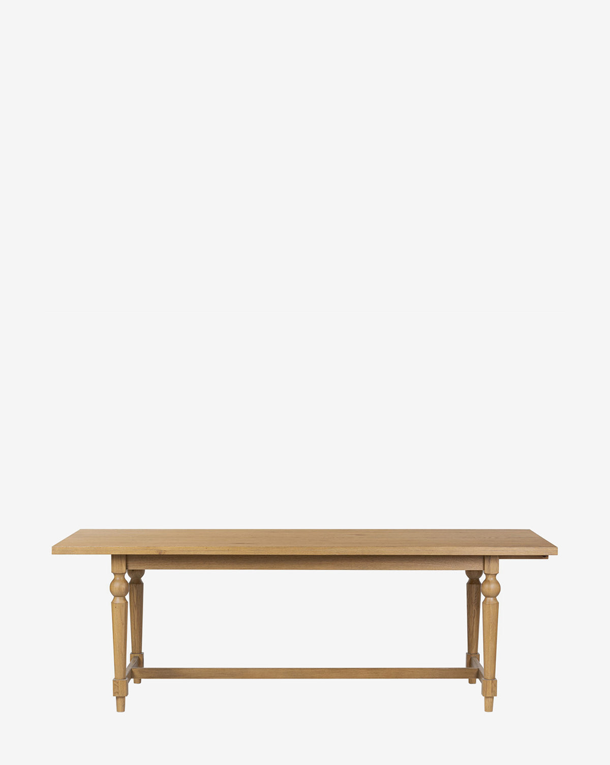 The Kyler Oak Extension Dining Table is a Scandinavian modern piece with a rectangular wooden top, turned legs, and a simple crossbar, shown against a plain white background by McGee & Co.