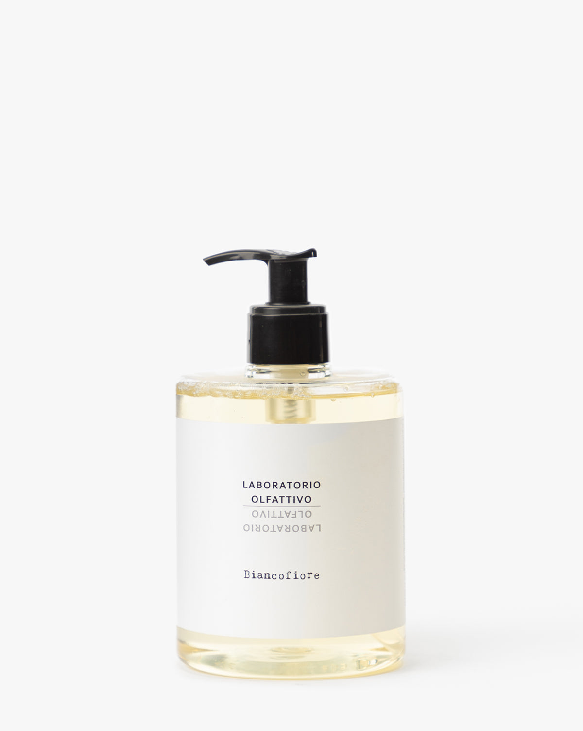 A clear pump bottle of pale yellow Laboratorio Olfattivo Liquid Soap, made with olive and coconut oil, is shown against a plain white background.