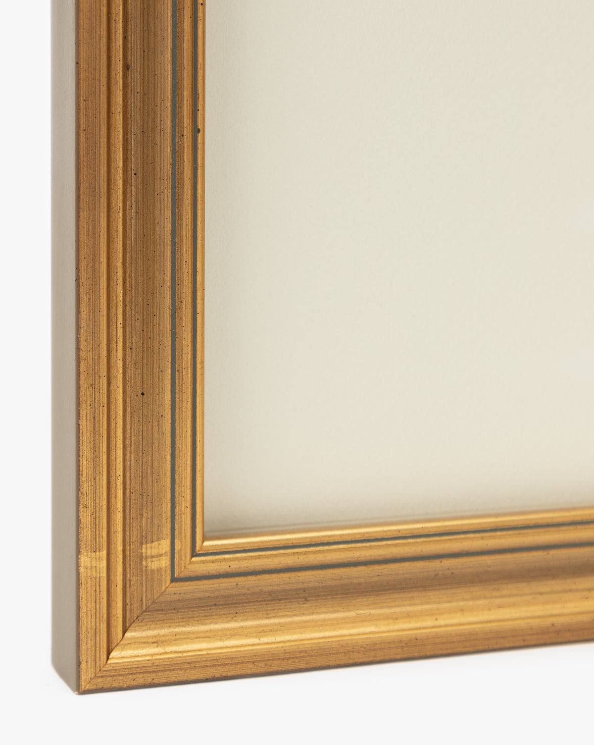 Close-up of the corner of the Lace Detail gold-colored wooden picture frame, featuring grooved accents and a metallic sheen—ideal for showcasing wall art and elevating your home decor with an elegant touch, by McGee & Co.